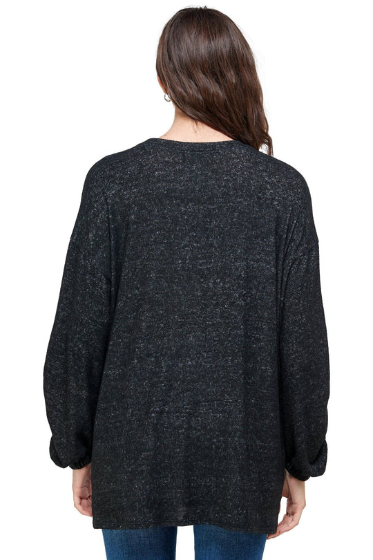 Person wearing a dark gray cardigan on a white background