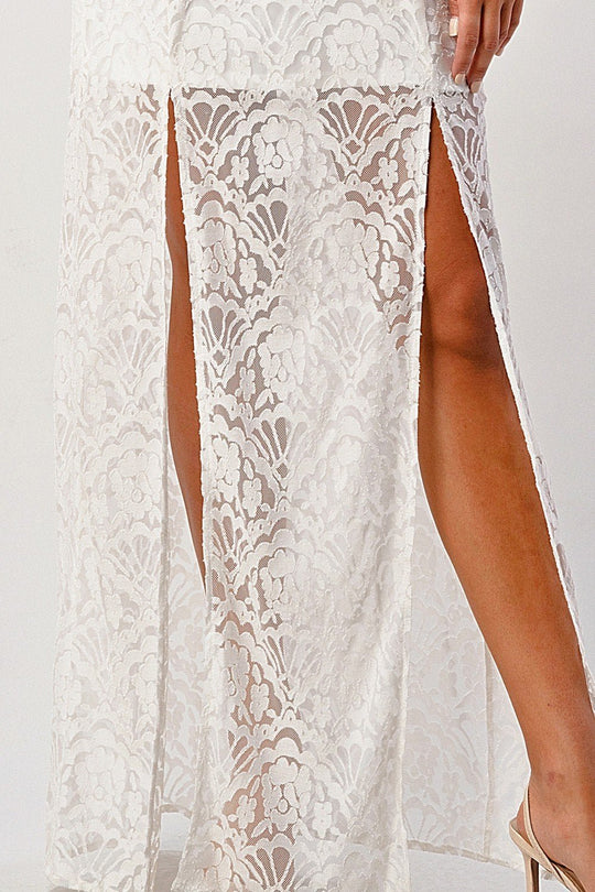 White lace dress with a high slit on a white background