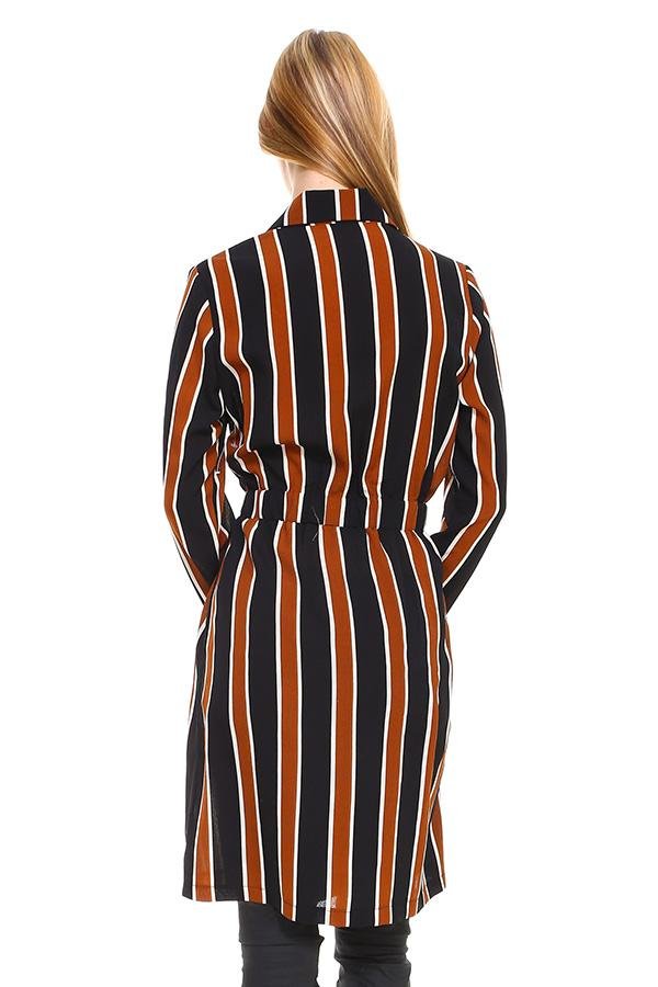 Woman wearing a black and orange striped dress with a white background