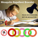 Child wearing colorful mosquito repellent wristband while doing homework