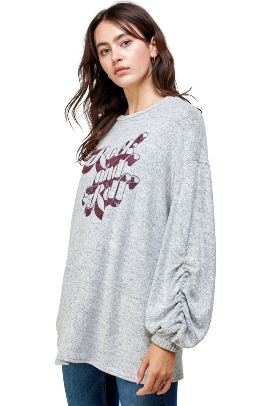 Woman wearing a gray sweatshirt with maroon text on a white background