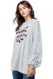 Woman wearing a gray sweatshirt with maroon text on a white background