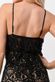 Black lace dress with thin straps on a plain background