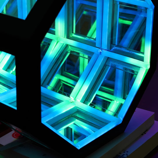 Geometric light sculpture with blue and green colors on a dark background