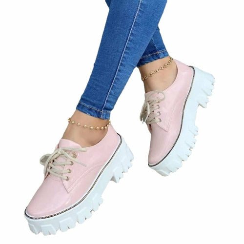 Pink platform shoes worn with blue jeans on a white background