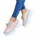 Pink platform shoes worn with blue jeans on a white background