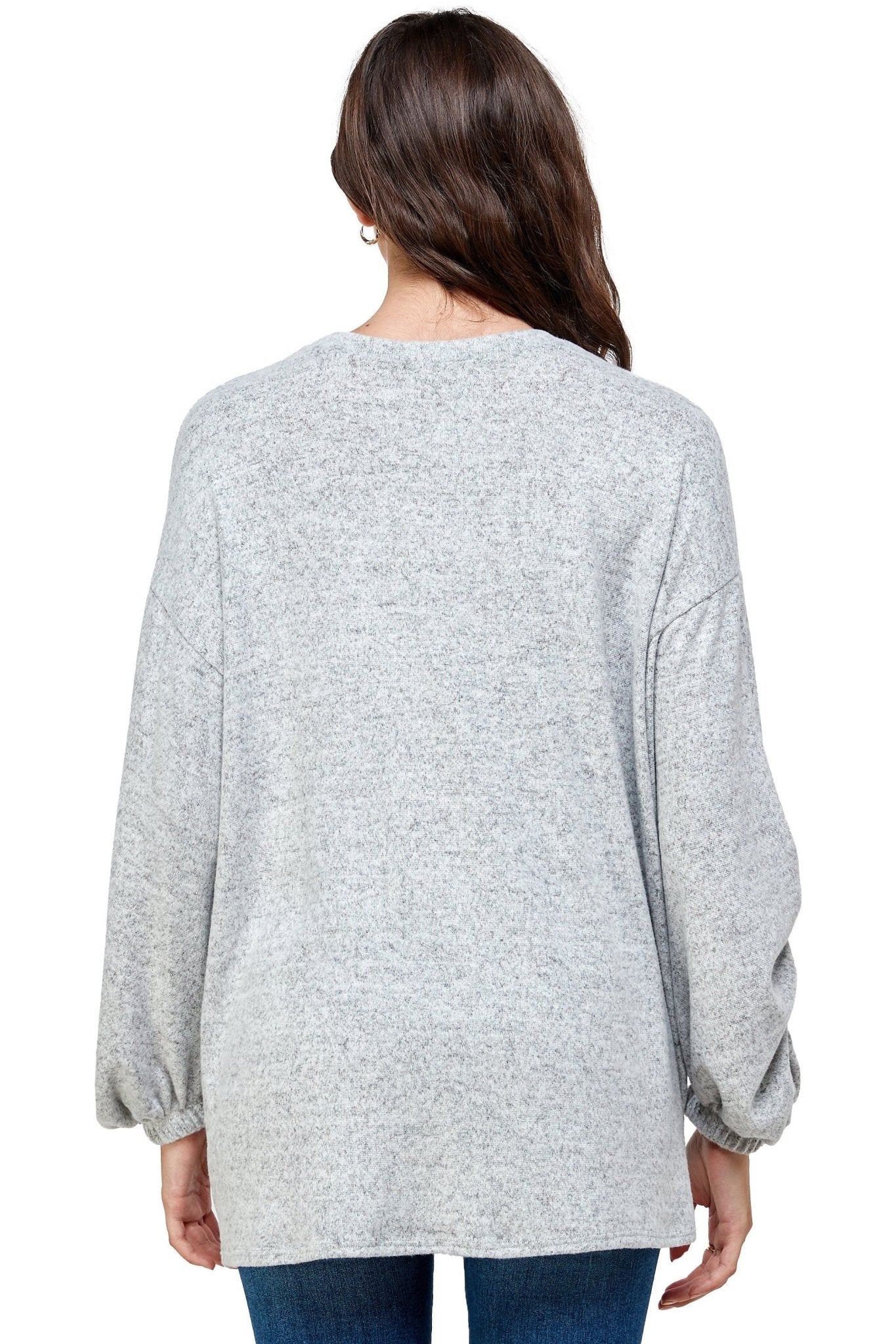 Person wearing a gray sweater on a white background