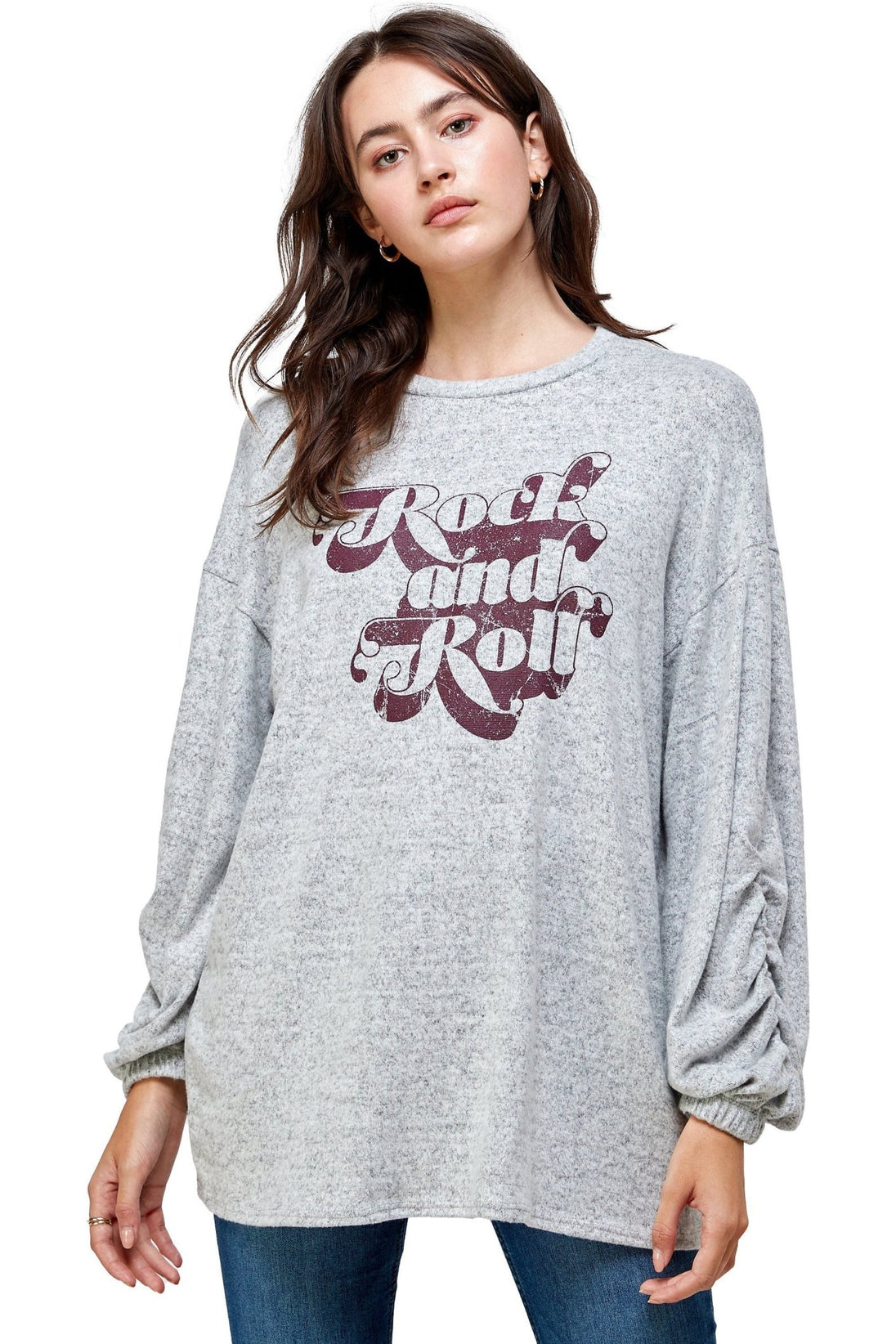 Woman wearing a gray sweater with 'Rock and Roll' text on a white background
