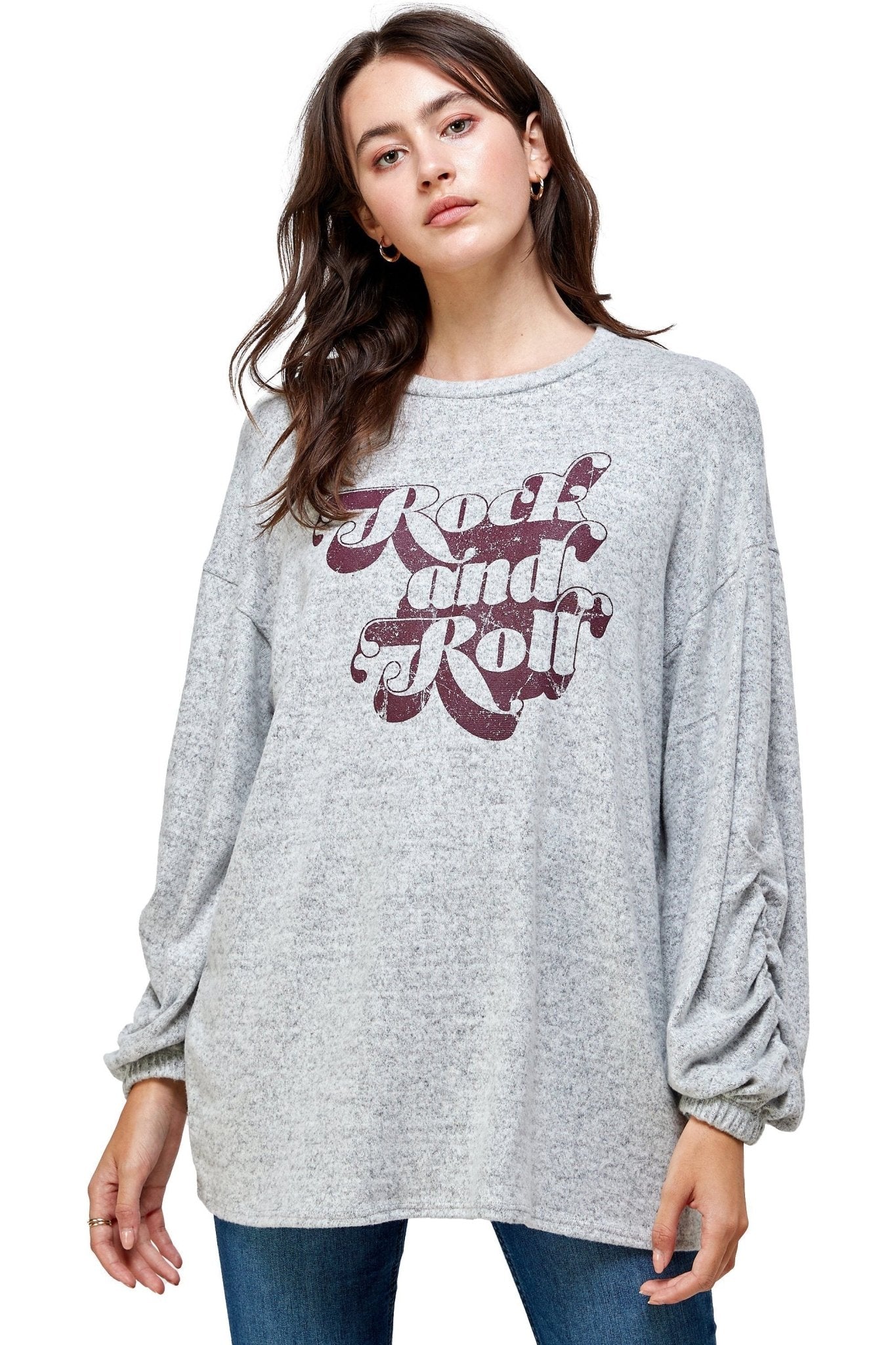 Woman wearing a gray sweater with 'Rock and Roll' text on a white background