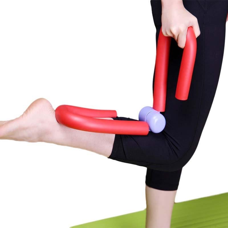 Person using a red and purple exercise tool on their leg against a white background