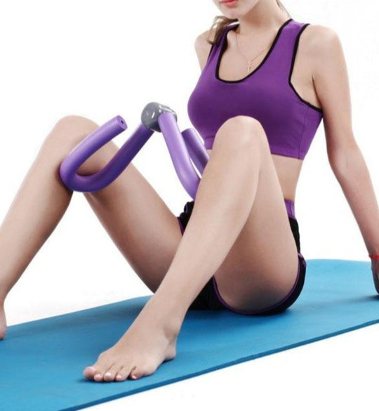 Person using a purple exercise roller on a blue mat